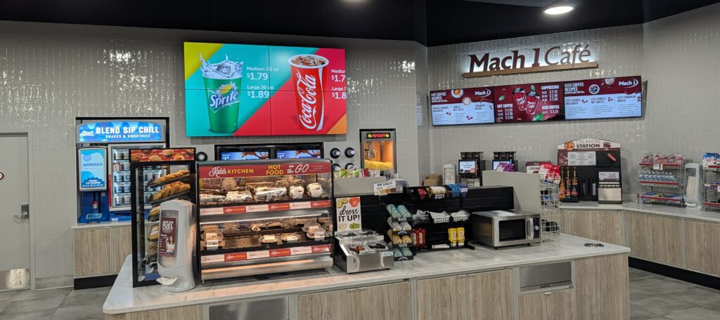 This photo shows the digital menu boards installed at the Mach 1 Café, part of a full-store transformation completed by EyeCatch Networks. The commercial-grade displays showcase dynamic content, improve visibility, and create a modern customer experience inside the convenience store.